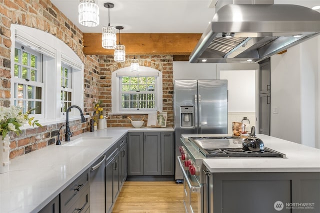 1542 Grand Ave, Seattle, WA 98122 - kitchen with a sink, gray cabinets, appliances with stainless steel finishes, brick wall, and island range hood