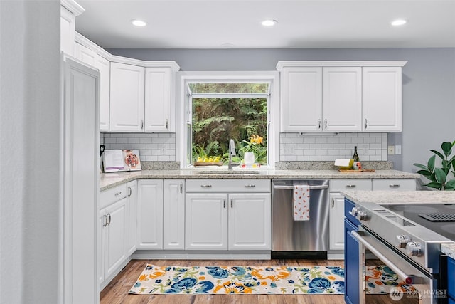17655 Division Ave NE, Suquamish, WA 98392 - kitchen featuring appliances with stainless steel finishes, a sink, white cabinets, decorative backsplash, and recessed lighting