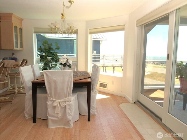 1599 E Ocean Shores Blvd SW Unit 2E, Ocean Shores, WA 98569 - dining area featuring a chandelier, light wood finished floors, and healthy amount of natural light