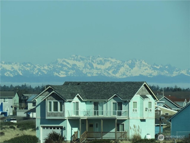 1599 E Ocean Shores Blvd SW Unit 2E, Ocean Shores, WA 98569 - view of front of property with a balcony, covered porch, a garage, and a mountain view