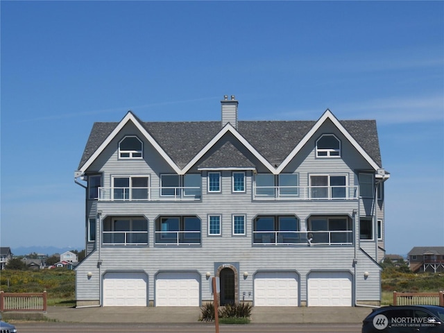 1599 E Ocean Shores Blvd SW Unit 2E, Ocean Shores, WA 98569 - townhome / multi-family property with an attached garage, a chimney, a shingled roof, and driveway