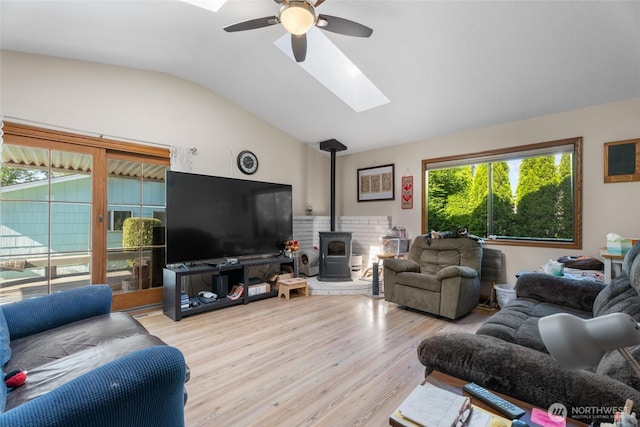 2649 Louisiana St, Longview, WA 98632 - living area featuring a skylight, vaulted ceiling, a ceiling fan, a wood stove, and wood finished floors