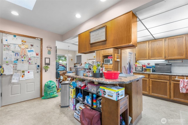 2649 Louisiana St, Longview, WA 98632 - kitchen with brown cabinetry, a center island, and recessed lighting