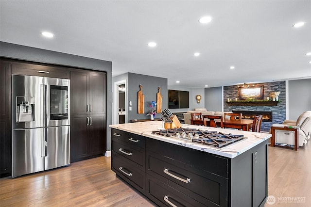 15530 73rd Ave SE, Snohomish, WA 98296 - kitchen with stainless steel appliances, light wood-style floors, a fireplace, a center island, and recessed lighting