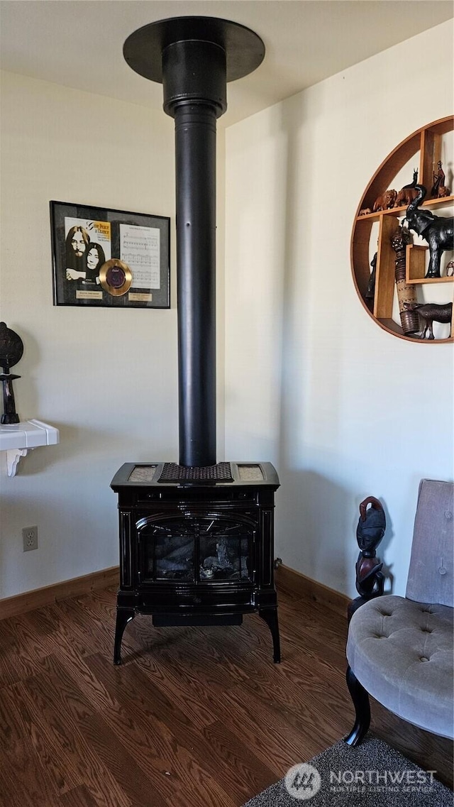 211 NW 25th St, Long Beach, WA 98631 - detailed view of a wood stove, wood finished floors, and baseboards