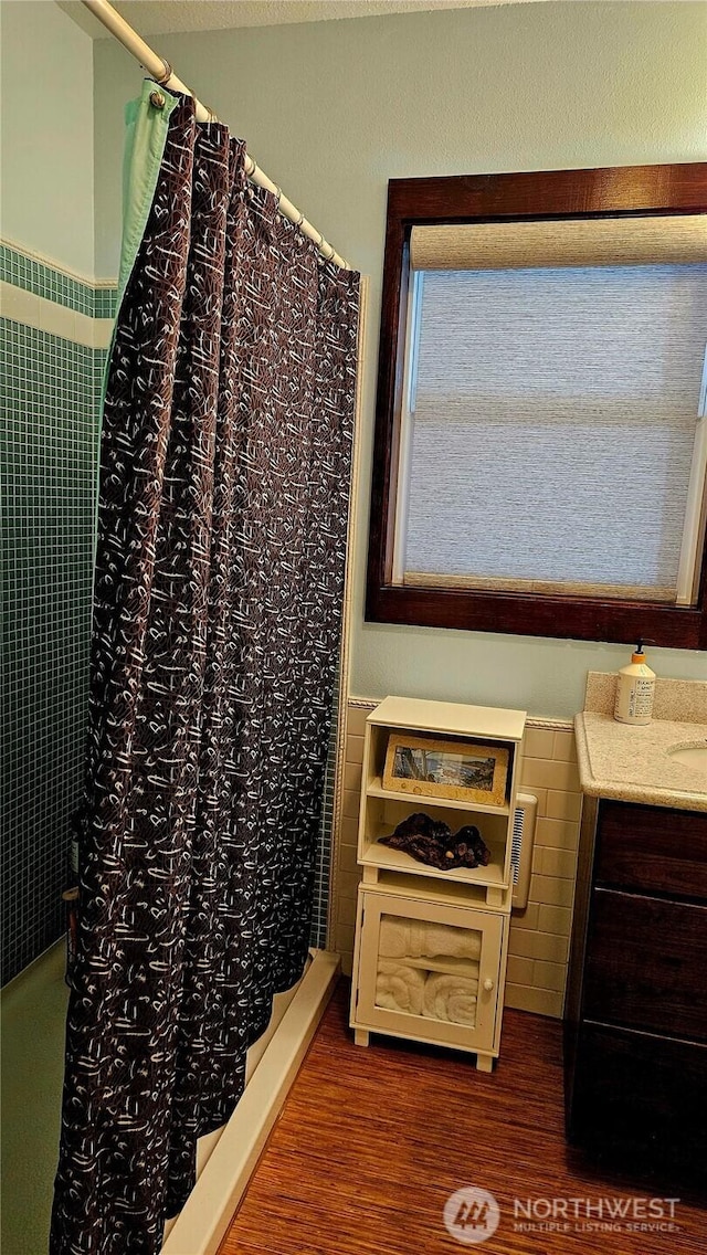 211 NW 25th St, Long Beach, WA 98631 - bathroom featuring a shower with shower curtain, wood finished floors, and vanity