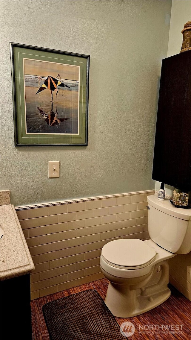 211 NW 25th St, Long Beach, WA 98631 - half bath featuring toilet, tile walls, vanity, and wainscoting