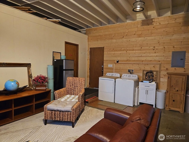 211 NW 25th St, Long Beach, WA 98631 - living room with washer and clothes dryer, electric panel, wooden walls, and concrete floors
