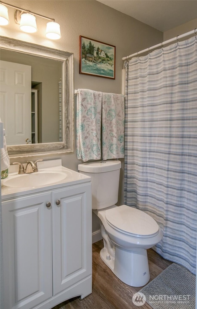 142 Sea Breeze Loop SE, Ocean Shores, WA 98569 - full bath with toilet, vanity, wood finished floors, and a shower with shower curtain