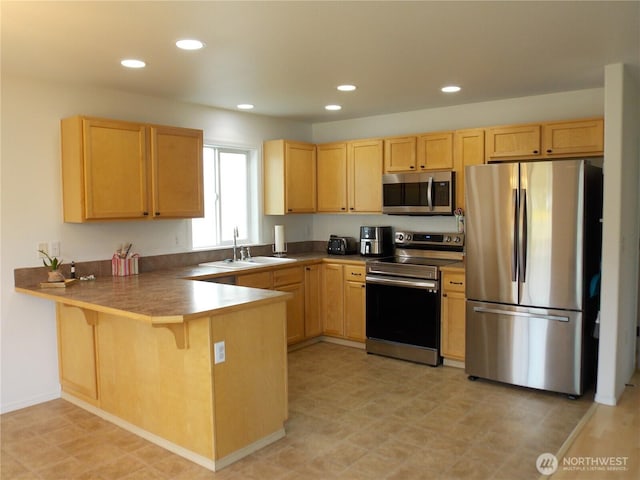 10717 Umtanum St SE, Yelm, WA 98597 - kitchen featuring stainless steel appliances, a sink, light brown cabinets, a peninsula, and recessed lighting