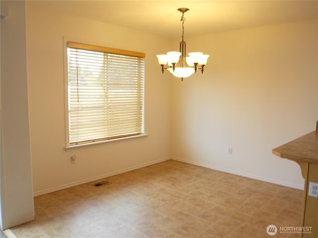 10717 Umtanum St SE, Yelm, WA 98597 - unfurnished dining area with a chandelier, light flooring, and baseboards