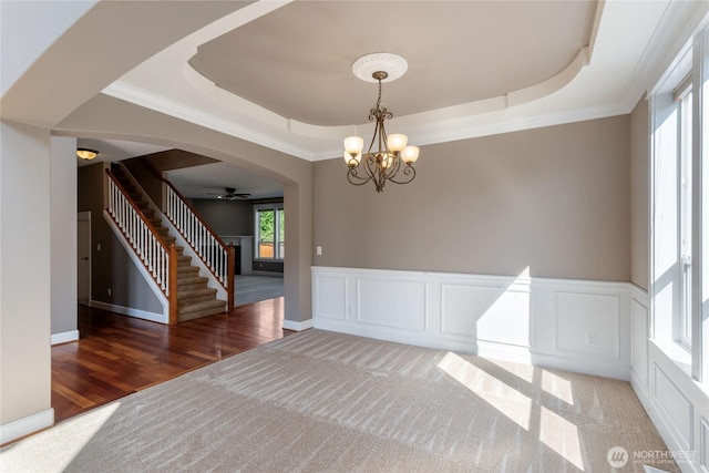 19333 205th St E, Orting, WA 98360 - unfurnished dining area featuring a raised ceiling, stairs, a chandelier, crown molding, and arched walkways