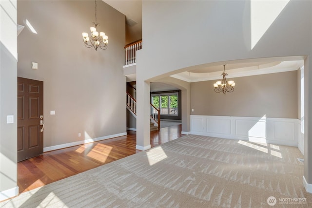 19333 205th St E, Orting, WA 98360 - foyer entrance with a chandelier, arched walkways, wood finished floors, stairway, and a high ceiling