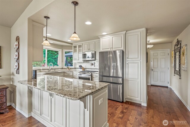 8 Clearview Dr, Longview, WA 98632 - kitchen with appliances with stainless steel finishes, a peninsula, white cabinetry, light stone counters, and glass insert cabinets
