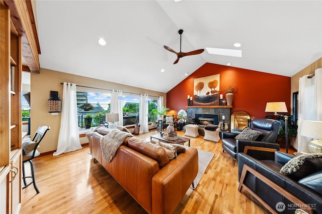 714 13th St, Bellingham, WA 98225 - living area with a skylight, ceiling fan, a glass covered fireplace, lofted ceiling, and light wood-style floors