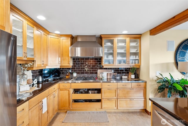 714 13th St, Bellingham, WA 98225 - kitchen featuring wall chimney range hood, stainless steel countertops, appliances with stainless steel finishes, backsplash, and glass insert cabinets