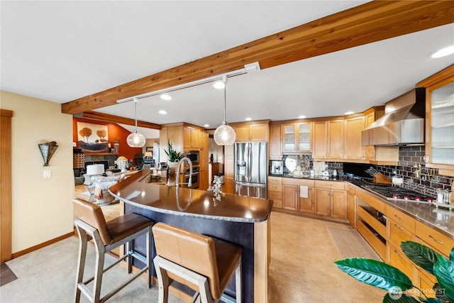 714 13th St, Bellingham, WA 98225 - kitchen with stainless steel appliances, wall chimney range hood, beam ceiling, a breakfast bar area, and decorative backsplash