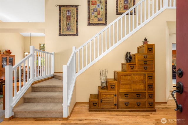 2041 NW Tregaten Ln, Poulsbo, WA 98370 - stairs featuring wood finished floors, a high ceiling, and baseboards