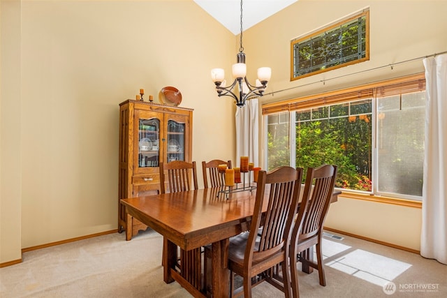 2041 NW Tregaten Ln, Poulsbo, WA 98370 - dining room with light carpet, a chandelier, high vaulted ceiling, and baseboards