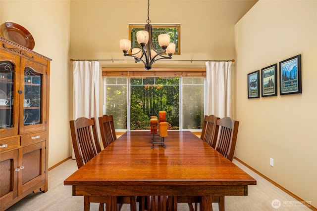 2041 NW Tregaten Ln, Poulsbo, WA 98370 - dining room featuring a chandelier, a high ceiling, light colored carpet, and baseboards