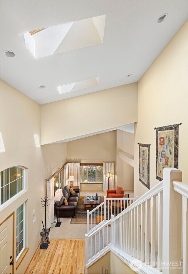 2041 NW Tregaten Ln, Poulsbo, WA 98370 - stairway with a skylight, wood finished floors, recessed lighting, and a towering ceiling