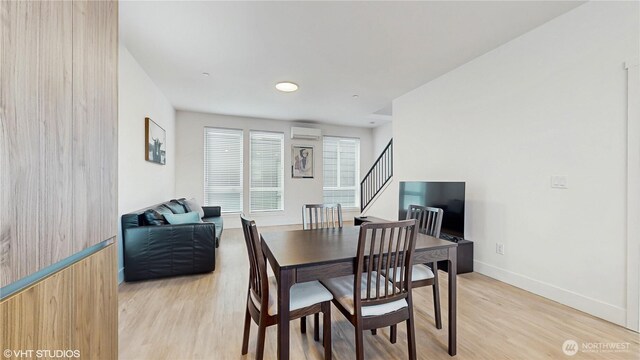 444 13th Ave, Seattle, WA 98122 - dining room featuring light wood-style floors, baseboards, stairs, and a wall mounted air conditioner