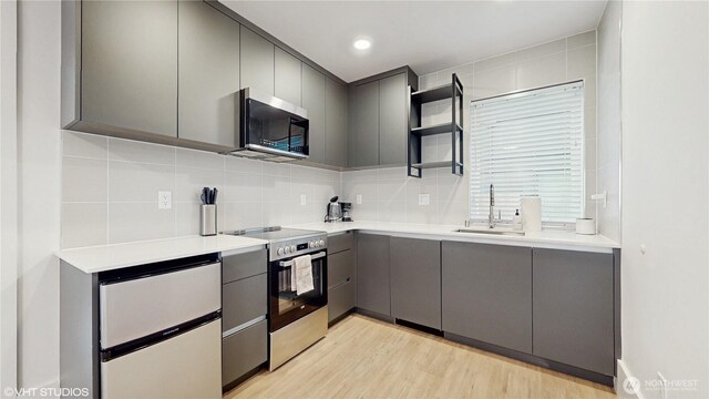 444 13th Ave, Seattle, WA 98122 - kitchen with gray cabinets, stainless steel appliances, decorative backsplash, a sink, and open shelves