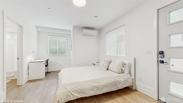 444 13th Ave, Seattle, WA 98122 - bedroom featuring a wall mounted air conditioner, light wood finished floors, and baseboards