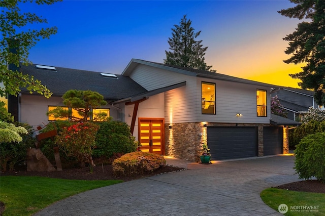 12 Columbia Ky, Bellevue, WA 98006 - view of front facade featuring an attached garage, driveway, and stone siding