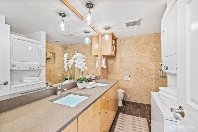 3834 175th Ave NE Unit 101, Redmond, WA 98052 - bathroom with stacked washer / dryer, double vanity, a shower, tile walls, and wood finished floors