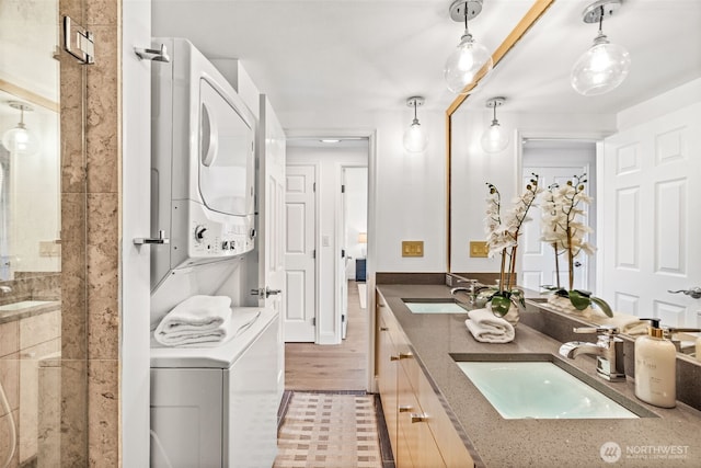 3834 175th Ave NE Unit 101, Redmond, WA 98052 - bathroom featuring estacked washer and dryer, double vanity, and a shower stall
