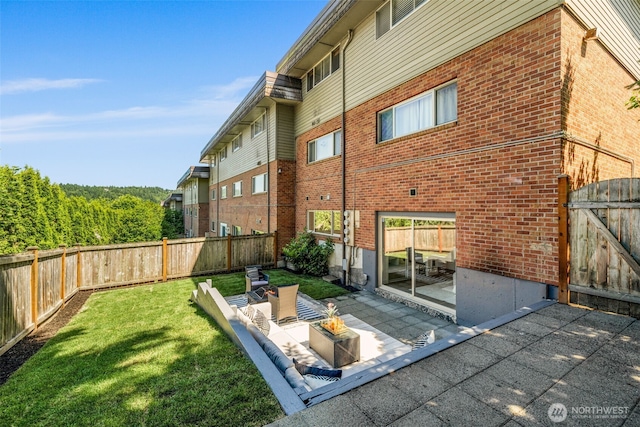 3834 175th Ave NE Unit 101, Redmond, WA 98052 - rear view of house with brick siding, a fenced backyard, a patio area, and a gate