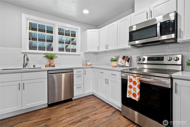 2319 Washington St SE, Olympia, WA 98501 - kitchen featuring appliances with stainless steel finishes, a sink, light countertops, white cabinets, and recessed lighting