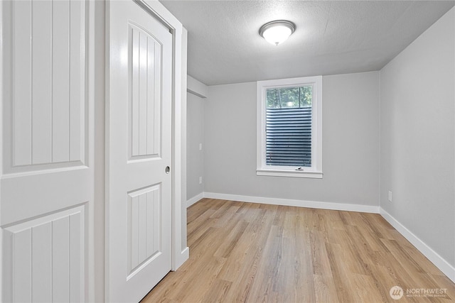 2319 Washington St SE, Olympia, WA 98501 - unfurnished bedroom featuring light wood-type flooring, baseboards, and a textured ceiling