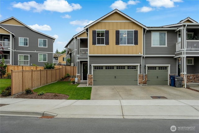 8323 E Gilman Ave, Arlington, WA 98223 - view of front of house featuring board and batten siding, an attached garage, concrete driveway, stone siding, and a balcony
