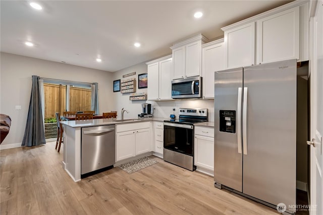 8323 E Gilman Ave, Arlington, WA 98223 - kitchen featuring appliances with stainless steel finishes, a sink, a peninsula, white cabinets, and recessed lighting