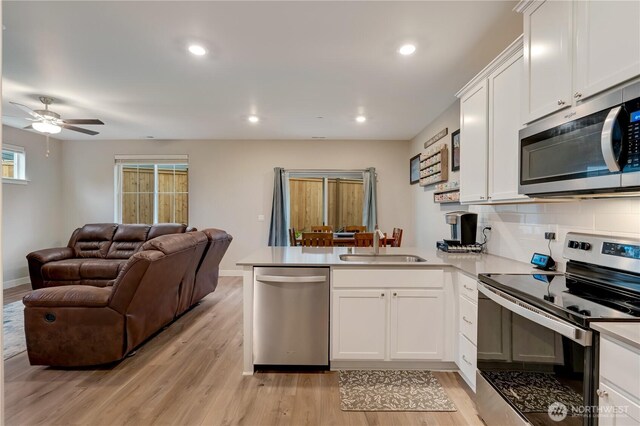 8323 E Gilman Ave, Arlington, WA 98223 - kitchen with stainless steel appliances, a sink, a peninsula, open floor plan, and a ceiling fan