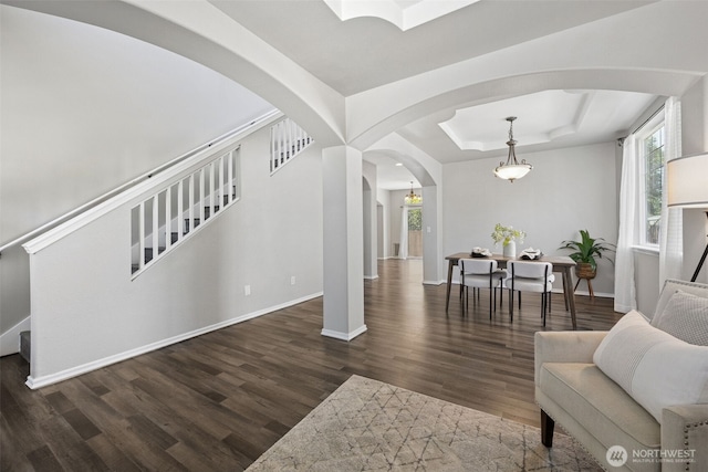 18216 80th Ave E, Puyallup, WA 98375 - living room with arched walkways, a raised ceiling, wood finished floors, baseboards, and plenty of natural light
