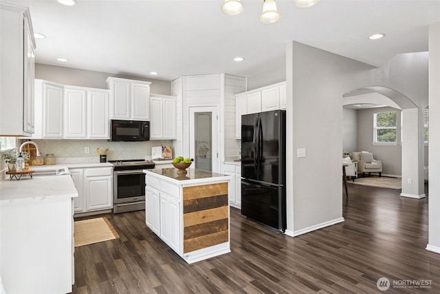 18216 80th Ave E, Puyallup, WA 98375 - kitchen featuring black appliances, a sink, arched walkways, decorative backsplash, and white cabinetry