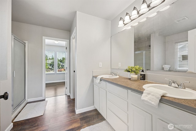 18216 80th Ave E, Puyallup, WA 98375 - full bathroom with a stall shower, double vanity, wood finished floors, and baseboards