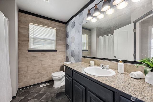 18216 80th Ave E, Puyallup, WA 98375 - bathroom featuring tile patterned flooring, vanity, tile walls, plenty of natural light, and toilet