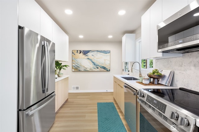 4022 N 19th St, Tacoma, WA 98406 - kitchen featuring stainless steel appliances, a sink, light countertops, tasteful backsplash, and light wood-style floors