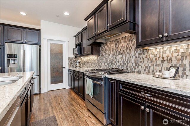 6214 207th Ave E, Bonney Lake, WA 98391 - kitchen featuring stainless steel appliances, light stone counters, dark brown cabinets, and recessed lighting