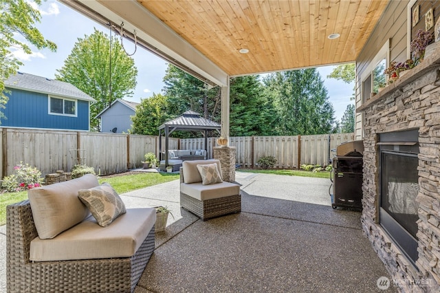 6214 207th Ave E, Bonney Lake, WA 98391 - fenced backyard with a gazebo, a patio area, an outdoor living space with a fireplace, and area for grilling