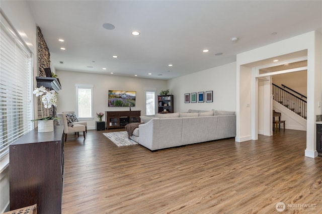 6214 207th Ave E, Bonney Lake, WA 98391 - living area with a glass covered fireplace, wood finished floors, stairway, recessed lighting, and baseboards