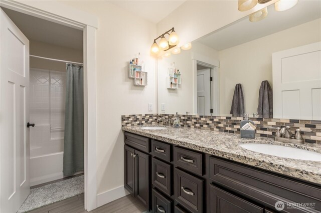 6214 207th Ave E, Bonney Lake, WA 98391 - bathroom featuring double vanity, backsplash, wood finished floors, shower / bath combination with curtain, and baseboards
