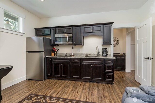 6214 207th Ave E, Bonney Lake, WA 98391 - kitchen featuring appliances with stainless steel finishes, a sink, dark wood-type flooring, and light stone countertops