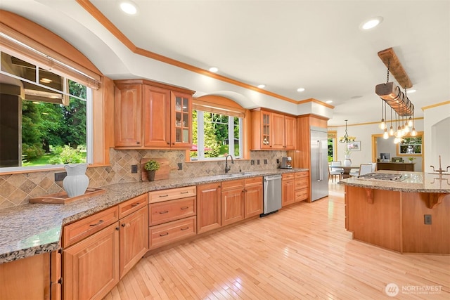 8795 Wood Duck Way, Blaine, WA 98230 - kitchen with appliances with stainless steel finishes, a breakfast bar, light wood finished floors, glass insert cabinets, and ornamental molding