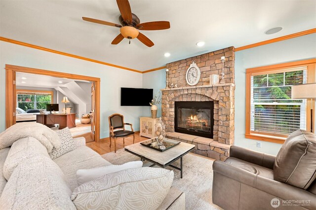 8795 Wood Duck Way, Blaine, WA 98230 - living area with wood finished floors, a ceiling fan, a fireplace, plenty of natural light, and ornamental molding
