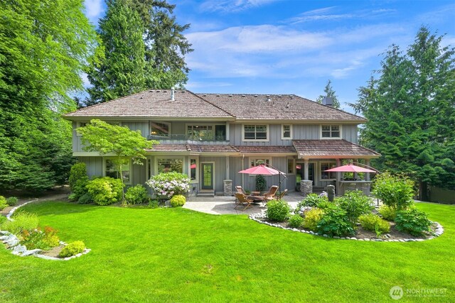 8795 Wood Duck Way, Blaine, WA 98230 - back of property with a balcony, board and batten siding, a patio, and a lawn